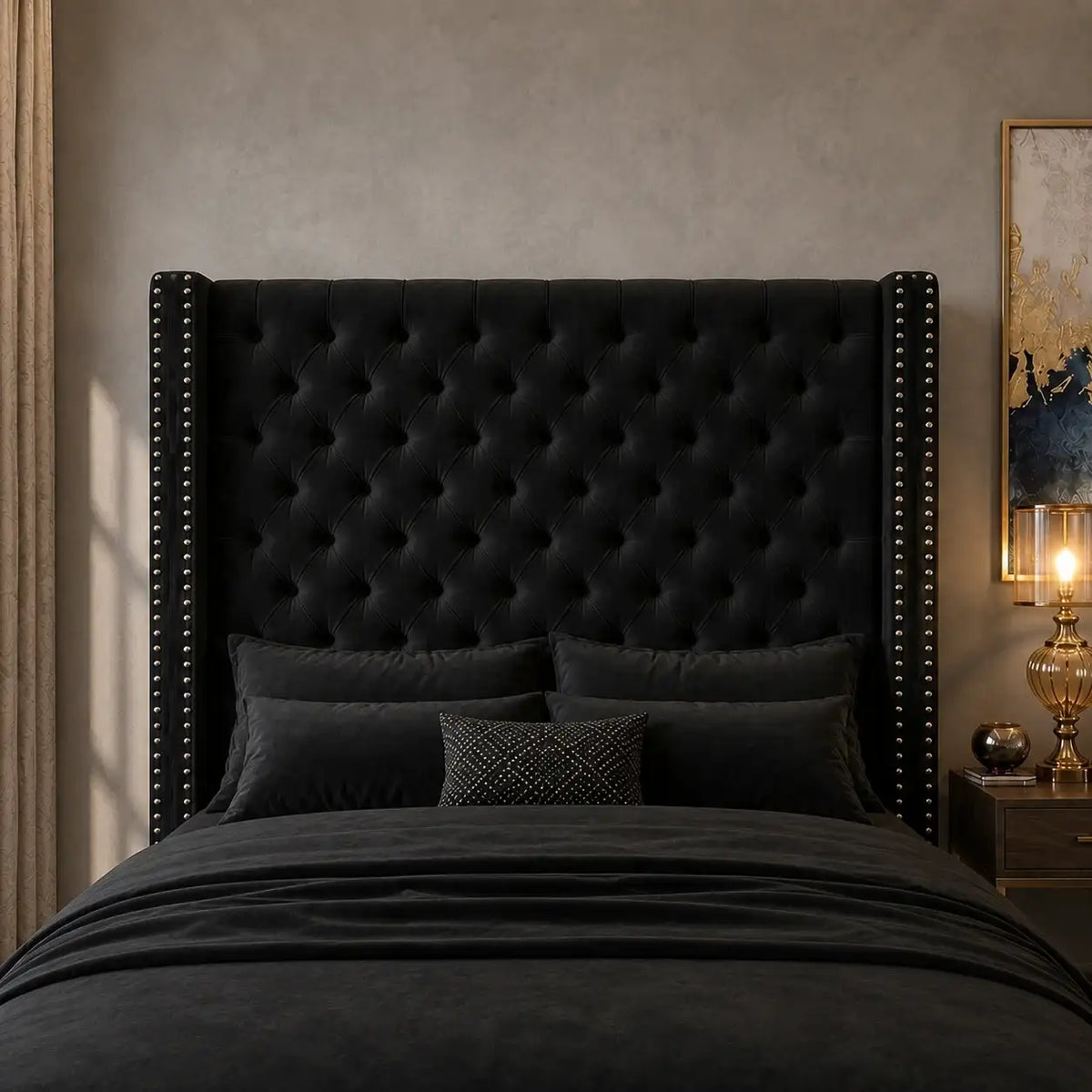 Close-up of black velvet high headboard with deep diamond button tufting and silver nailhead trim