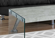 Close-up of high-quality cement-look top and sturdy tempered glass legs on this modern coffee table