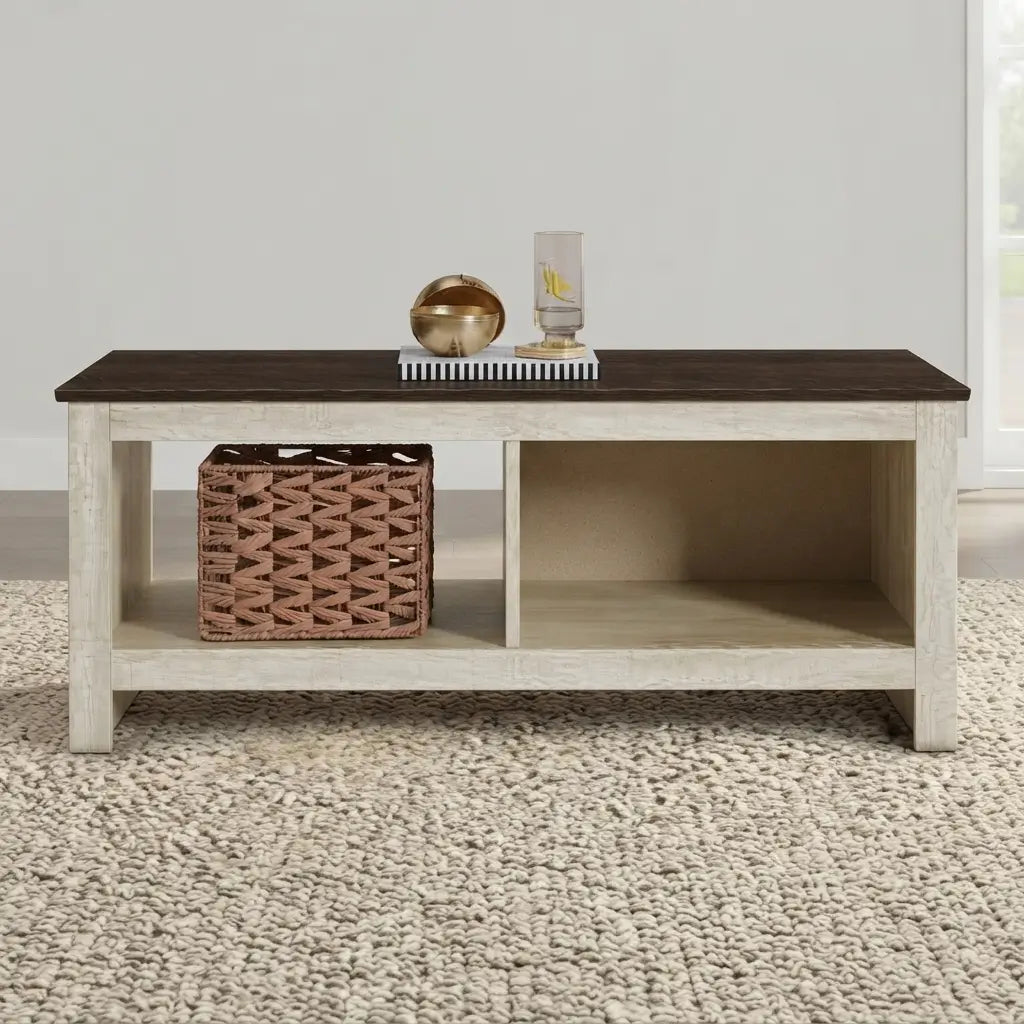 A rustic modern coffee table with a dark brown top and a distressed white frame, styled with a woven basket and decorative objects on a textured beige rug.