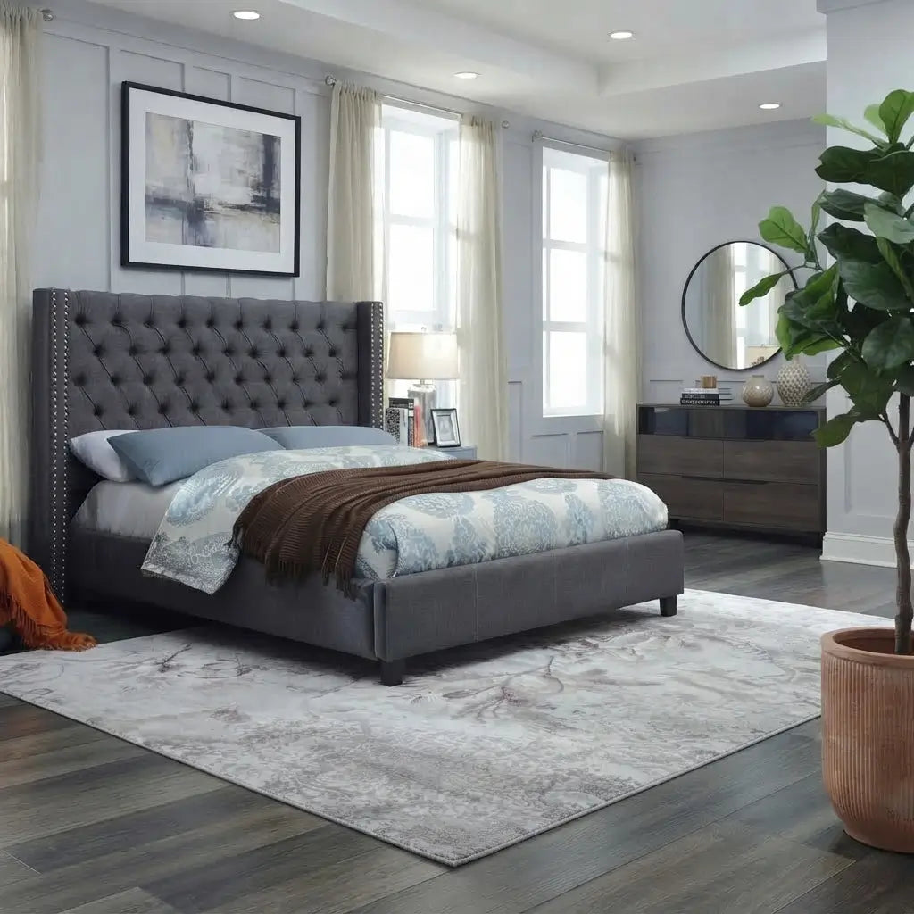Grey upholstered high headboard bed frame in a modern bedroom setup