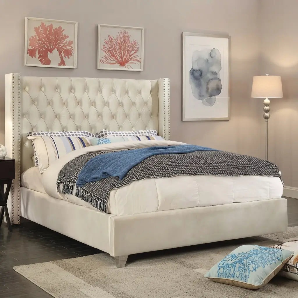 Close-up of beige velvet headboard with deep button tufting and nailheads