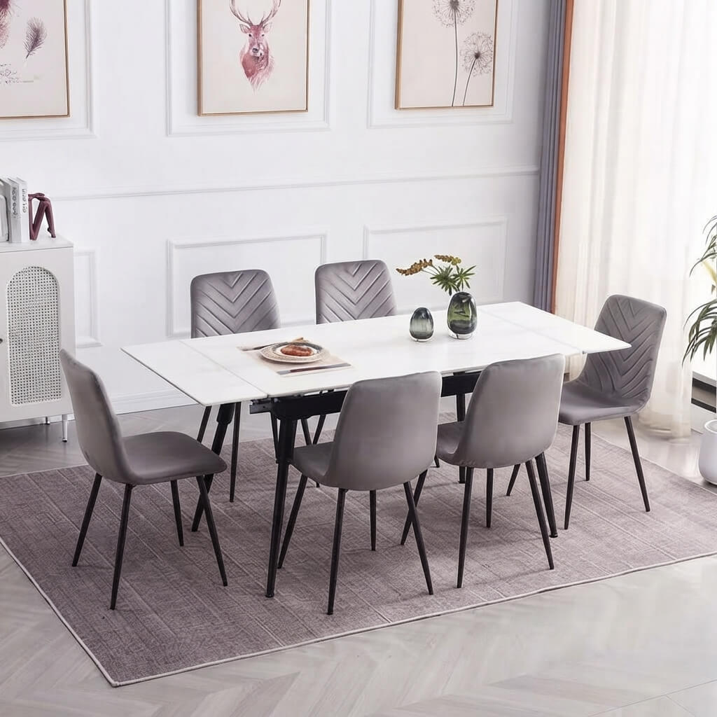 A modern dining set featuring a rectangular white marble-top table with black metal legs and six gray upholstered chairs with chevron and smooth backrests, arranged on a textured gray rug in a bright, contemporary dining room.