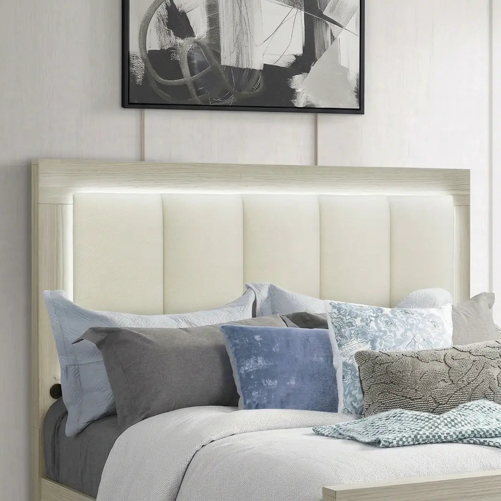 Close-up view of a light oak wooden headboard with white vertical channel tufted upholstery and integrated ambient LED lighting glow.