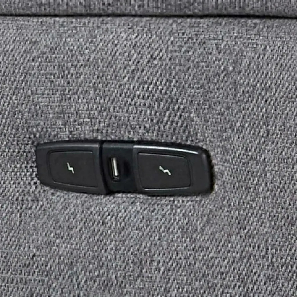 Close-up view of power recliner side control buttons and USB charging port on grey fabric upholstery
